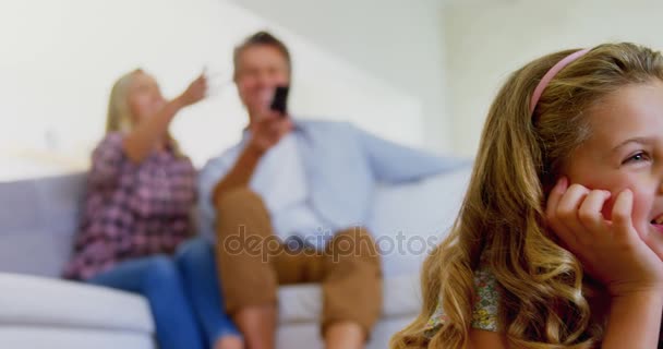 Семья смотрит телевизор вместе в гостиной — стоковое видео