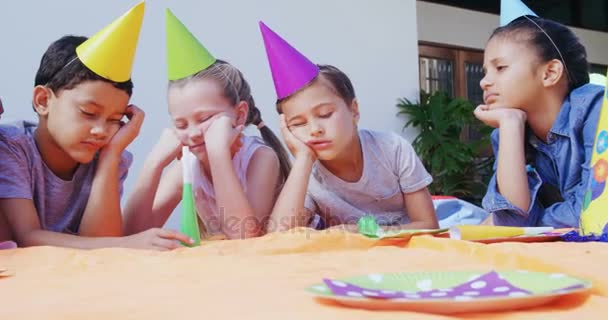 Расстроенные дети лежат на заднем дворе дома — стоковое видео