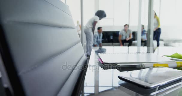 Telefone celular e documento na mesa enquanto os colegas discutem em segundo plano 4k — Vídeo de Stock