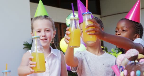 Crianças brindando as garrafas de suco — Vídeo de Stock