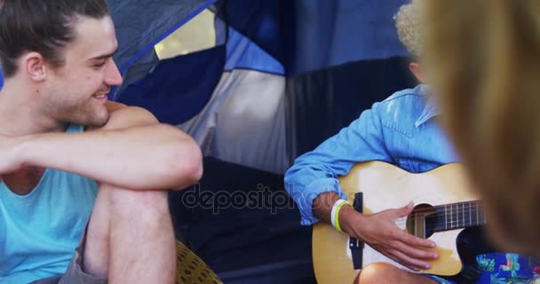 Člověk hraje na kytaru své přátele na hudebním festivalu — Stock video