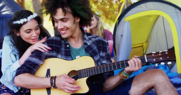 Чоловік грає на гітарі для своєї жінки в парку — стокове відео
