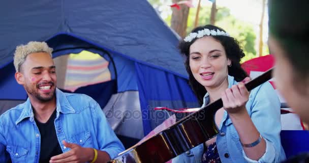 Kvinna passerar gitarr till hennes vänner på musikfestival — Stockvideo