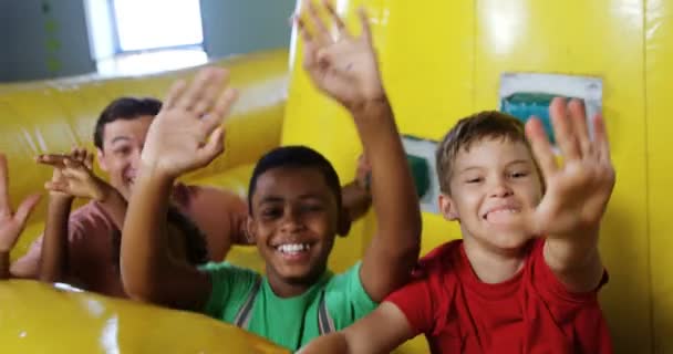 Niños jugando en castillo hinchable — Vídeo de stock