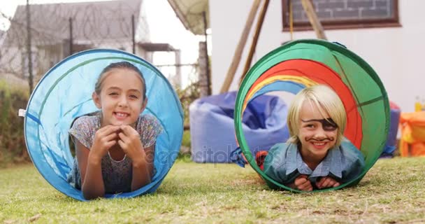 Portret van gelukkige jonge geitjes in tent tunnel — Stockvideo