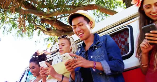 Amigos usando telefone celular perto de van campista no parque — Vídeo de Stock