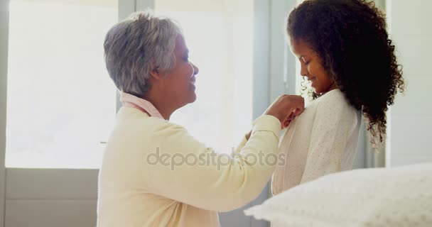 Abuela vistiendo a su nieta en el dormitorio — Vídeos de Stock