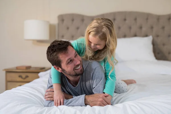 Far och dotter ha kul på sängen — Stockfoto