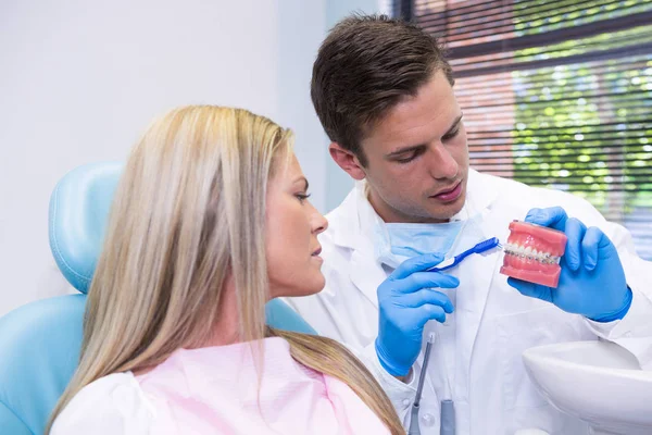 Tandläkaren visar dental mögel till kvinna — Stockfoto