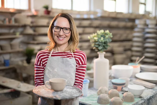 Vrouwelijke potter bedrijf cup — Stockfoto