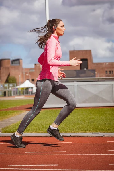 Frau joggt auf Rennstrecke — Stockfoto