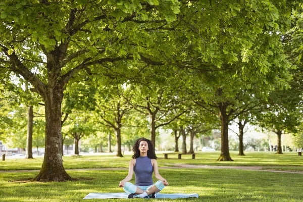 Femme effectuant du yoga dans le parc — Photo