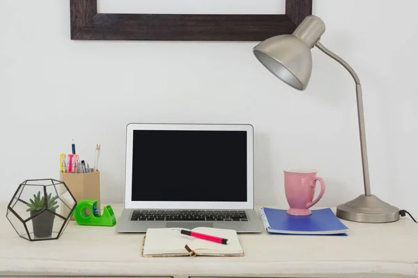 Ноутбук и различные офисные принадлежности на столе — стоковое фото
