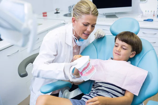 Dentista tenendo stampi dentali parlando con ragazzo — Foto Stock