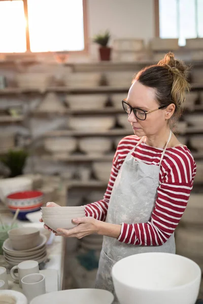 Kvinnliga potter holding stack av skålar — Stockfoto