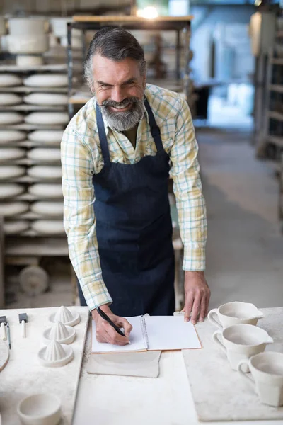 Erkek potter defter siparişlerini denetleme — Stok fotoğraf