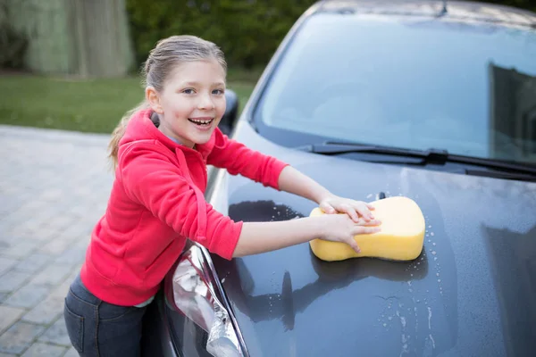 Teenager-Mädchen wäscht an sonnigem Tag ein Auto — Stockfoto