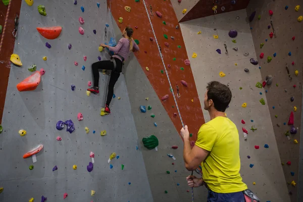 Mann mit Seil blickt auf Sportler-Kletterwand — Stockfoto
