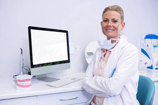 Dentista trabalhando enquanto sentado por computador — Fotografia de Stock