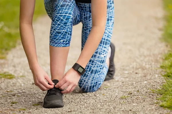 Donna allacciatura lacci scarpe nel parco — Foto Stock