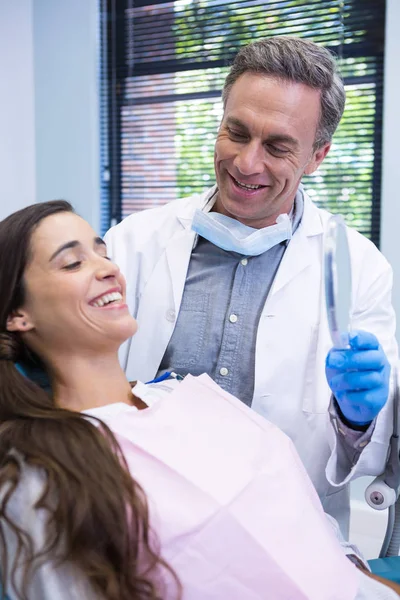 Dentist showing mirror to patient — Stock Photo, Image