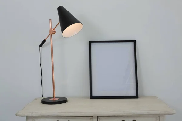 Fotolijst en verlichte lamp op tafel — Stockfoto