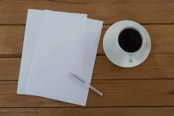 Café preto e papel em branco na prancha de madeira — Fotografia de Stock