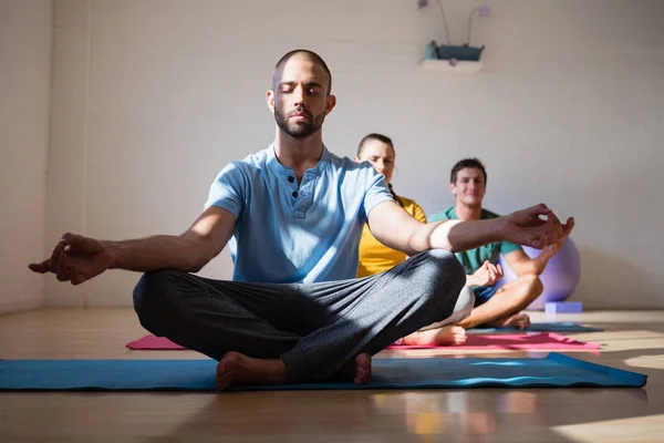 Mannelijke instructeur met studenten mediteren in club — Stockfoto