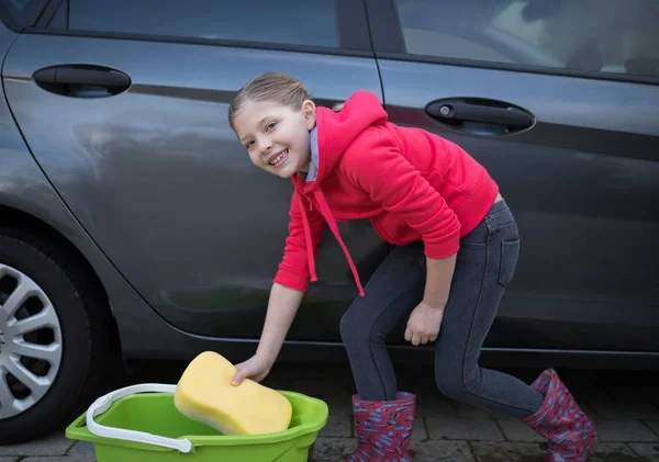 Genç kız güneşli bir günde bir araba yıkama — Stok fotoğraf