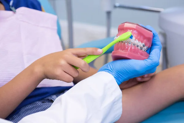 Zahnarzt lehrt Jungen Zähneputzen auf Prothesen — Stockfoto