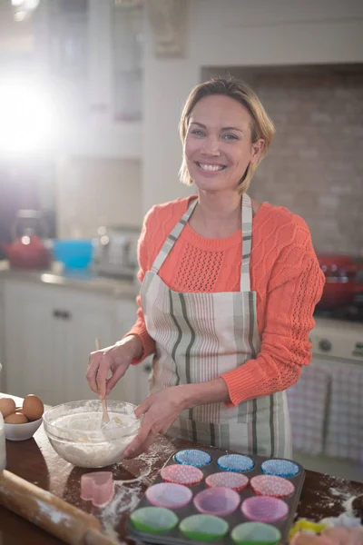 Woman mixing eggs and wheat flour — Stock Photo, Image