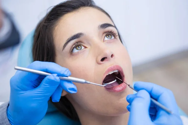 Dentista examinando mulher na clínica médica — Fotografia de Stock