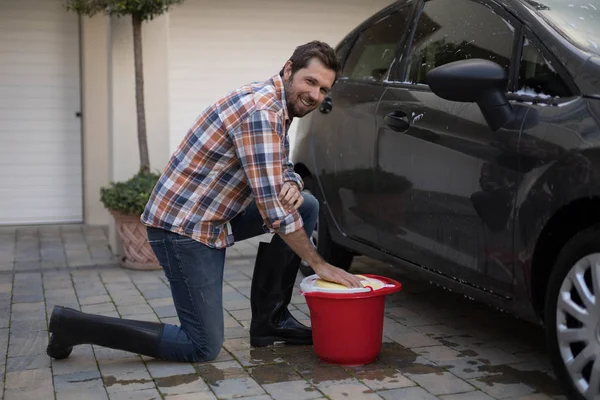 Mann wäscht an einem sonnigen Tag ein Auto — Stockfoto