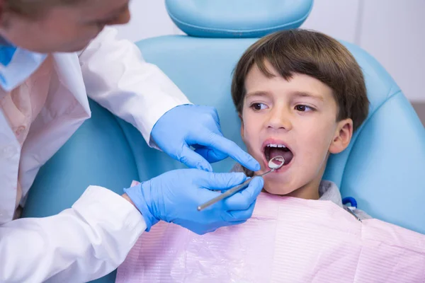 Dentista examinando menino na clínica — Fotografia de Stock