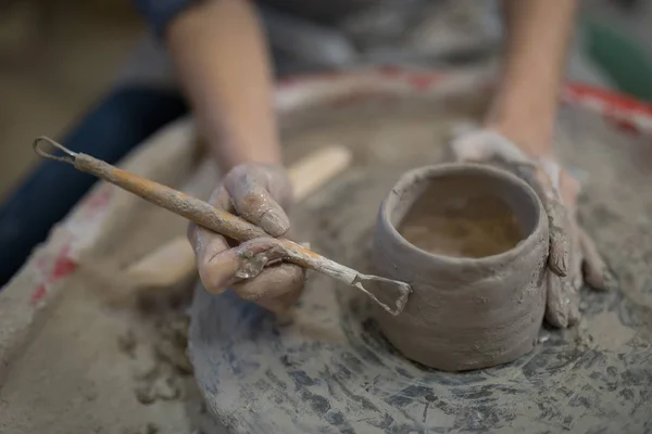 Vrouwelijke potter molding plaat met handgereedschap — Stockfoto