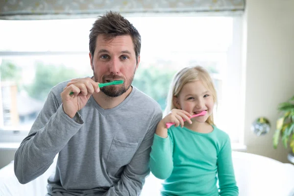 Far och dotter borstar tänderna — Stockfoto