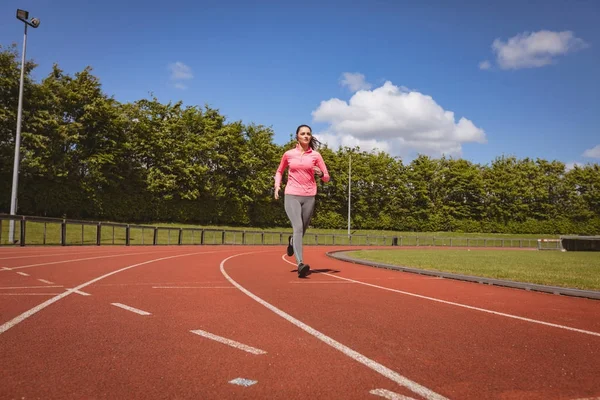 Kvinna som jogging på en racerbana — Stockfoto