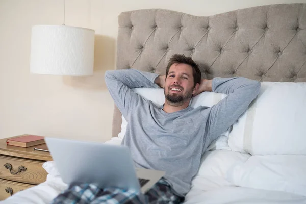 Homme utilisant un ordinateur portable au lit — Photo
