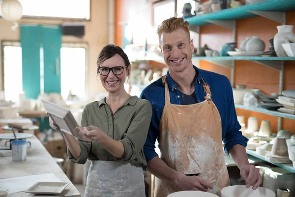 Male and female potter checking plate — Stock Photo, Image