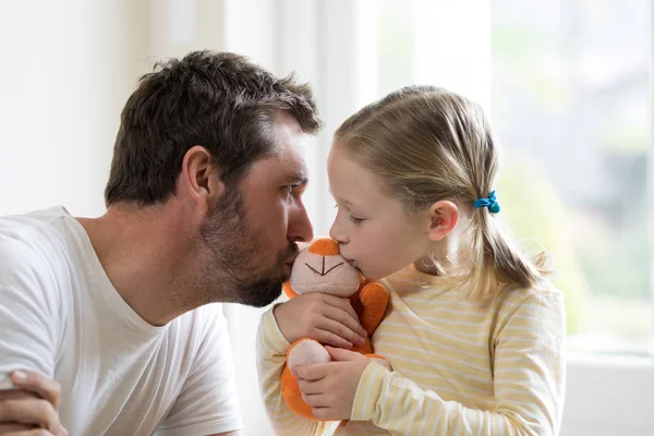 Pai e filha beijando brinquedo macio — Fotografia de Stock