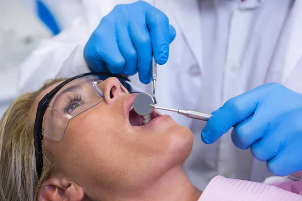 Врач осматривает женщину в стоматологической клинике — стоковое фото