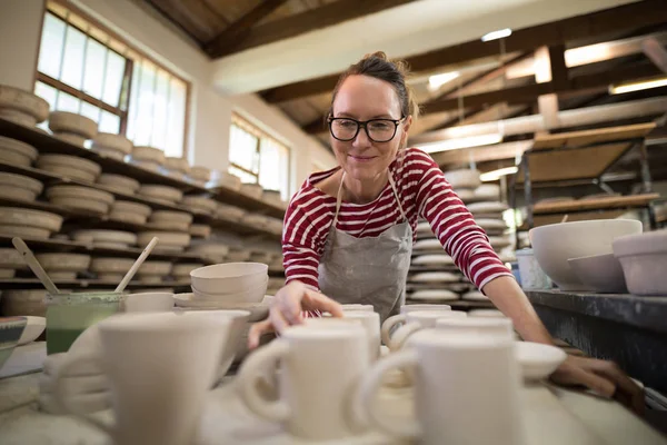 Mujer comprobar tazas en worktop — Foto de Stock