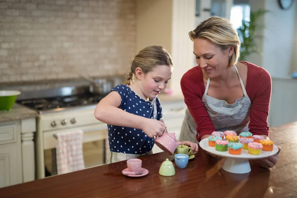 Moeder en dochter gieten thee — Stockfoto