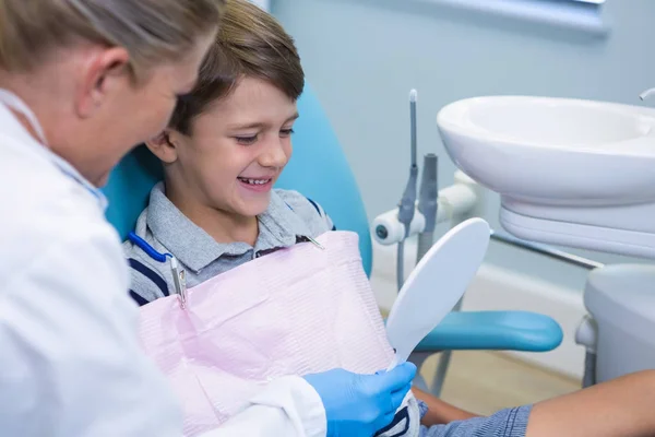 Dentista mostrando mirrior para menino — Fotografia de Stock