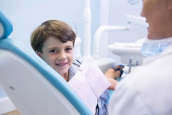 Boy sitting on dentist chair by dentist — Stock Photo, Image