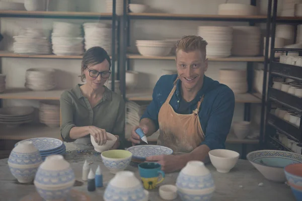 Manliga och kvinnliga potter dekorera skål — Stockfoto