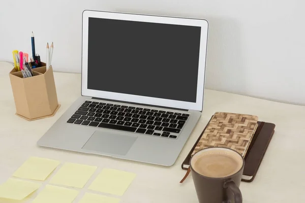 Ноутбук и различные офисные принадлежности на столе — стоковое фото