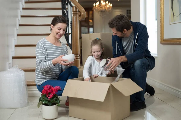 Padres e hija abriendo cajas de cartón — Foto de Stock