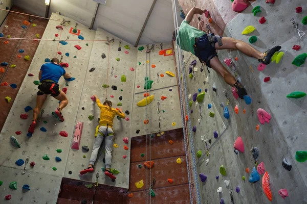 Athletes rock climbing in health club — Stock Photo, Image