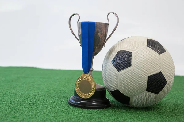 Fotbal, trofeje a medaile na umělé trávě — Stock fotografie